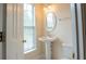 Charming half bath with pedestal sink, toilet and window with natural light at 5587 Trace Views Dr, Norcross, GA 30071
