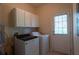 Laundry room with modern washer, dryer and white cabinets for storage at 5587 Trace Views Dr, Norcross, GA 30071