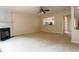 Open living room with fireplace, neutral carpet, ceiling fan and open view of kitchen at 5587 Trace Views Dr, Norcross, GA 30071