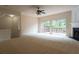 An expansive living room featuring neutral carpet, a fireplace, and sliding glass doors to a deck at 5587 Trace Views Dr, Norcross, GA 30071