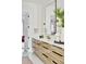 Modern bathroom featuring double sinks with wood grain cabinets, white countertops, and a large mirror at 3681 Hamilton Mill Rd, Buford, GA 30519