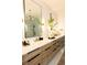 Bright bathroom featuring double sinks with wood grain cabinets, white countertops, and a large mirror at 3681 Hamilton Mill Rd, Buford, GA 30519