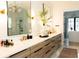 Modern bathroom featuring double sinks with wood grain cabinets, white countertops, and large mirrors at 3681 Hamilton Mill Rd, Buford, GA 30519