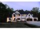 Elegant modern home featuring a white exterior with black accents, illuminated by evening lights at 3681 Hamilton Mill Rd, Buford, GA 30519