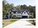 Beautiful modern home showcasing a white exterior, black trim, and spacious driveway at 3681 Hamilton Mill Rd, Buford, GA 30519