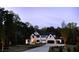 Modern home featuring a white exterior with black accents, beautifully lit during twilight at 3681 Hamilton Mill Rd, Buford, GA 30519