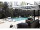 Outdoor patio with covered seating area, lounge chairs, and a beautiful view of the wooded landscape at 3681 Hamilton Mill Rd, Buford, GA 30519