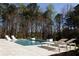 Beautiful pool with jacuzzi, sun loungers and water feature with a wooded landscape in the background at 3681 Hamilton Mill Rd, Buford, GA 30519