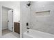 Bathroom featuring gray tilework, white tub, black fixtures, and a recessed shelf at 641 Charing Cross Dr, Marietta, GA 30066