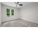 A bright bedroom with windows offering wooded views and neutral-toned walls and carpet at 641 Charing Cross Dr, Marietta, GA 30066