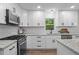 Updated kitchen with white cabinets, stainless steel appliances, granite countertops, and modern backsplash at 641 Charing Cross Dr, Marietta, GA 30066