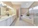 Bright bathroom featuring double sinks, soaking tub, tiled floors, and a glass enclosed shower for a spa-like experience at 70 Parkside Cir, Marietta, GA 30068