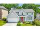 Charming two-story home featuring a red front door, manicured landscaping, and a two-car garage at 70 Parkside Cir, Marietta, GA 30068