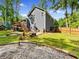 Grassy backyard with wooden deck and rock feature, surrounded by trees at 2723 Horseshoe Creek Sw Dr, Marietta, GA 30064