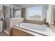 Bright bathroom with a soaking tub, tiled shower, and a window at 3422 Hopi Pt, Lawrenceville, GA 30044