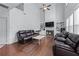 Bright living room boasts a fireplace, a ceiling fan, dark wood floors, and two dark sofas at 3422 Hopi Pt, Lawrenceville, GA 30044