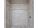 Elegant shower with large, light-colored tiles and mosaic flooring at 3422 Hopi Pt, Lawrenceville, GA 30044
