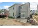 Spacious backyard with a patio, grill, and lush greenery surrounding a two-story home, perfect for entertaining at 121 Camdyn Cir, Woodstock, GA 30188