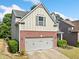 Two-story home featuring a brick facade, attached garage, and well-maintained landscaping at 121 Camdyn Cir, Woodstock, GA 30188