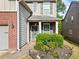 Inviting front entrance featuring a gray door, brick accents, and lush, manicured landscaping at 121 Camdyn Cir, Woodstock, GA 30188
