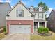 Charming two-story home featuring a brick facade, well-maintained lawn, and attached two-car garage at 121 Camdyn Cir, Woodstock, GA 30188