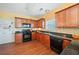 Kitchen featuring wood cabinets, black appliances, and granite counters, with tile backsplash and wood floors at 121 Camdyn Cir, Woodstock, GA 30188