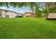 Wide backyard with manicured lawn and mature trees featuring a back view of the home at 2240 Clanton Ter, Decatur, GA 30034