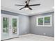 Bright bedroom featuring neutral walls, plush carpeting, a ceiling fan and a window and glass panel doors at 2240 Clanton Ter, Decatur, GA 30034