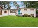 Charming white brick home featuring a manicured lawn, blue front door, and contrasting black trim at 2240 Clanton Ter, Decatur, GA 30034