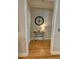 Hallway featuring hardwood floors, neutral paint, and a decorative table with a mirror at 2771 Middlecreek Way, Cumming, GA 30041