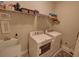 Efficient laundry room with modern washer, dryer, sink, and organized shelving for supplies at 2771 Middlecreek Way, Cumming, GA 30041