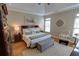 Bedroom with a tray ceiling, hardwood floors, and a cozy sitting area at 2771 Middlecreek Way, Cumming, GA 30041