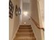 Carpeted staircase leads to the upper level, featuring natural wood railing and decorative wall art at 2771 Middlecreek Way, Cumming, GA 30041
