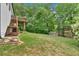 Grassy backyard featuring a deck with stairs to a patio area and a storage shed at 387 Rose Creek Pl, Woodstock, GA 30189