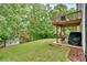 Backyard featuring a well-maintained lawn, a covered patio, and a storage shed at 387 Rose Creek Pl, Woodstock, GA 30189