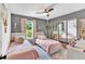 Cozy bedroom featuring two twin beds with pink bedding, mirrored closet, and ample natural light at 387 Rose Creek Pl, Woodstock, GA 30189