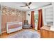 Comfortable baby bedroom featuring wallpaper, wood trim, and a cozy chair at 387 Rose Creek Pl, Woodstock, GA 30189