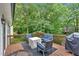 Outdoor deck featuring modern patio furniture and a barbecue grill surrounded by lush greenery at 387 Rose Creek Pl, Woodstock, GA 30189