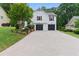 Spacious two-car garage with a long driveway and manicured landscaping at 387 Rose Creek Pl, Woodstock, GA 30189