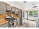 Well-lit kitchen featuring stainless steel appliances, granite countertops, and unique backsplash at 387 Rose Creek Pl, Woodstock, GA 30189