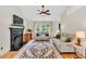 Bright living area featuring a fireplace, a ceiling fan, and natural light at 387 Rose Creek Pl, Woodstock, GA 30189