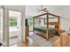 Spacious main bedroom with four poster bed, hardwood floors, and serene view at 387 Rose Creek Pl, Woodstock, GA 30189