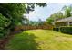 Well-manicured lawn in the backyard, complemented by a wooden privacy fence, mature trees, and beautiful landscaping at 690 Glenforest Rd, Sandy Springs, GA 30328