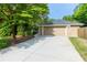 Long concrete driveway leading to a two-car garage with a brick exterior and mature trees surrounding the property at 690 Glenforest Rd, Sandy Springs, GA 30328