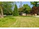 Spacious front yard with lush lawn, mature trees, and a long driveway leading to the home's two-car garage at 690 Glenforest Rd, Sandy Springs, GA 30328