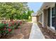 Landscaped walkway leading to the house, lined with vibrant pink roses and mature trees at 690 Glenforest Rd, Sandy Springs, GA 30328