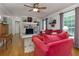 Bright living room featuring hardwood floors, neutral wall paint, a ceiling fan, and a red sofa set at 690 Glenforest Rd, Sandy Springs, GA 30328