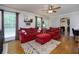 Bright living room featuring hardwood floors, a ceiling fan, neutral wall paint, and a red sofa set at 690 Glenforest Rd, Sandy Springs, GA 30328