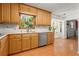 Efficient kitchen with wood cabinets, stainless steel dishwasher, and view of the yard at 2917 Rockbridge Rd, Marietta, GA 30066