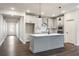 Modern kitchen boasts gray cabinets, stainless steel appliances, and an island with pendant lights at 3564 Arrow Root Cir, Loganville, GA 30052